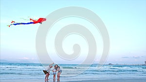 Happy Family With Child Launch a Kite, Mother Father and Daughter Playing with the Older Kite in the Ocean Background in