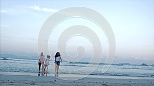 Happy family with child launch a kite, mother father and daughter playing with the older kite in the ocean background in