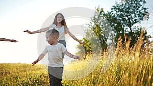Happy family. Child run together in the park at sunset silhouette. People in the park concept. Group of children