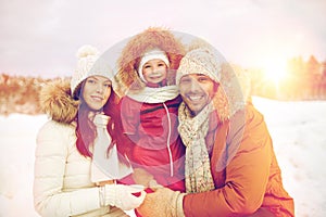 Happy family with child in winter clothes outdoors