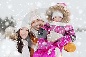 Happy family with child in winter clothes outdoors