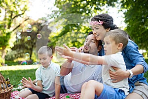 Family with children blow soap bubbles outdoors