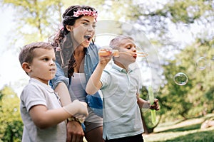 Family with children blow soap bubbles outdoors