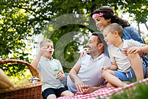 Family with children blow soap bubbles outdoors