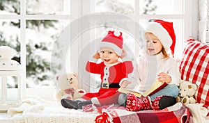 Happy family children brother and sister reading book on winter