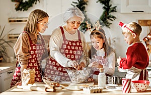 Happy family with children cooking together on Christmas day in cozy home kitchen