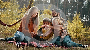 Happy family with children and a dog on picnic in an autumn park