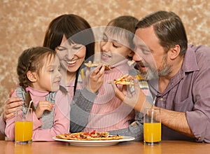 Happy family with children eating pizza
