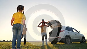 happy family. children fun kid play ball a together next to car watching the sunset silhouette in park. family travel