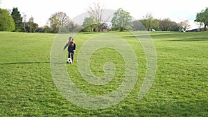 Happy Family Of Children Having Fun In Spring Park. Little Kid Run. Child Boy Dribbles Black White Classic Soccer Ball