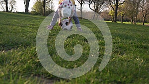 Happy Family Of Children Having Fun In Spring Park. Little Kid Run. Child Girl Dribbles Black White Classic Soccer Ball