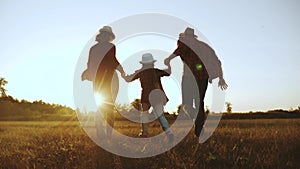 Happy family children kid run in the park at sunset. People in the park concept mom dad daughter and son joyful run