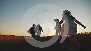 Happy family children kid together run in the park at sunset silhouette. people in the park concept mom dad daughter and