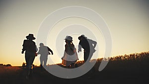 Happy family children kid together run in the park at sunset silhouette. people in the park concept mom dad daughter and