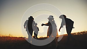 happy family children kid together run in the park at sunset silhouette. people in the park concept mom dad daughter and