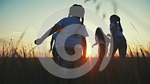 Happy family children kids together run in the park at sunset silhouette. people in the park concept mom dad daughter