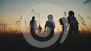 Happy family children kids together run in the park at sunset silhouette. people in the park concept mom dad daughter