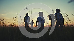 Happy family children kids together run in the park at sunset silhouette. people in the park concept mom dad daughter