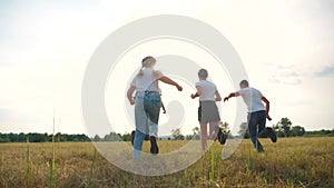 Happy family children kids together run in park at sunset silhouette. people in park concept mom a dad daughter and son