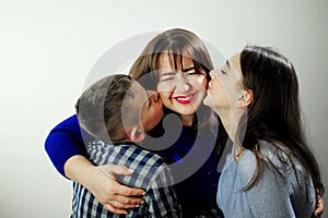 Daughter Girl 16 18 years Boy 12-15 Children from 2 sides kisses mom Happy family children kiss mom from two sides. Sons