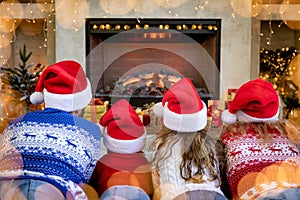 Happy family with children near fireplace at Christmas