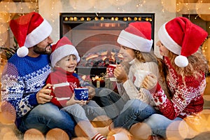 Happy family with children near fireplace at Christmas