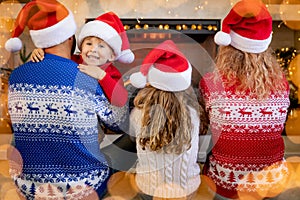 Happy family with children near fireplace at Christmas