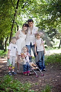 Happy family and children in park.