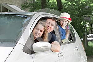 Happy family with children sitting in a family car