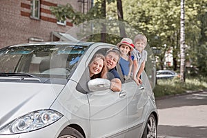 Happy family with children sitting in a family car