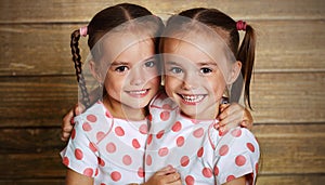 Happy family children twin sisters hugging