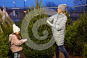 Happy family choosing christmas tree at market