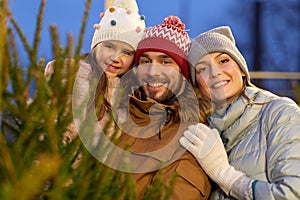 Happy family choosing christmas tree at market