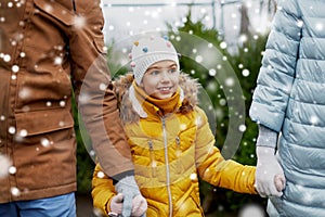 Happy family choosing christmas tree at market