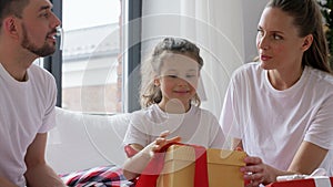 Happy family with Christmas gifts in bed at home