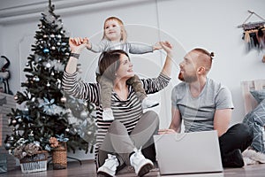 Happy family at christmas in morning opening gifts together near the fir tree. The concept of family happiness and well