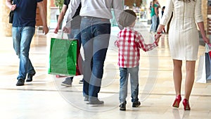 Happy Family Christmas shopping in mall. The boy with the mother and the father. Parents and child with packages with