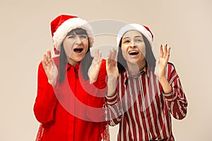 Happy family in Christmas sweater posing on a red background in the studio.