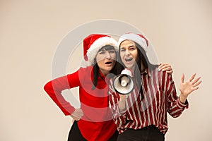 Happy family in Christmas sweater posing on a red background in the studio.