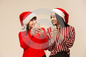 Happy family in Christmas sweater posing on a red background in the studio.