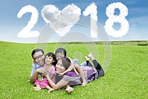 Happy family with clouds shaped number 2018