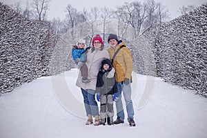 Happy family in cold winter park staying together.