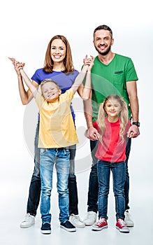 Happy family in colorful t-shirts having fun and looking at camera