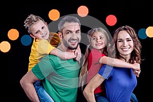 Happy family in colorful t-shirts hugging and smiling at camera