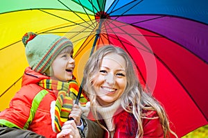 Happy family with colorful umbrella in autumn park