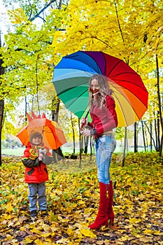 Happy family with colorful umbrellas in autumn park