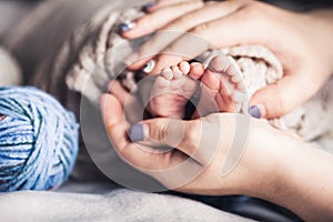 Happy Family concept. Baby feet in mother hands. Mom and her Child. Beautiful conceptual image of Maternity