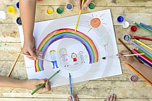 Happy family concept. Co-creation. Children hands draw on a sheet of paper: father, mother, boy and girl hold hands against