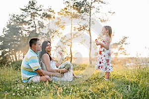 Happy family concept - father, mother and child daughter having fun and playing in nature