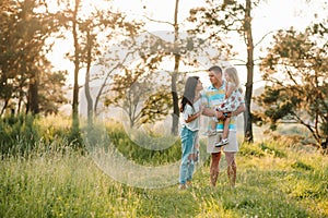 Happy family concept - father, mother and child daughter having fun and playing in nature